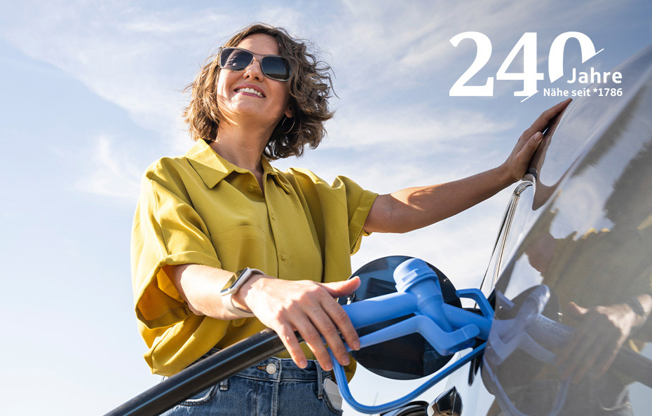 Eine Frau tankt lächelnd bei sonnigem Wetter ein Auto, oben rechts steht 240 Jahre Nähe seit 1786